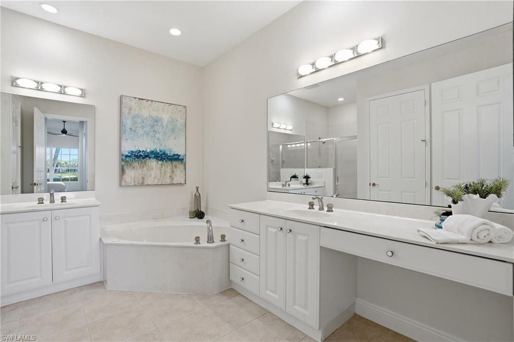 9263 Museo Circle, Unit 103 Naples, FL 34114 - Photo 19 of 49 Primary Bathroom with a stall shower, two vanities, a bath, and light tile patterned floors