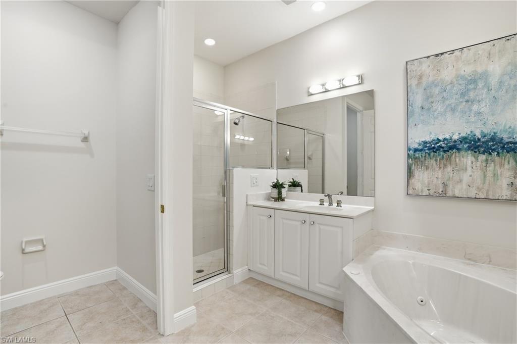9263 Museo Circle, Unit 103 Naples, FL 34114 - Photo 20 of 49 Primary bathroom with a shower stall, vanity, a whirlpool tub, and light tile patterned flooring
