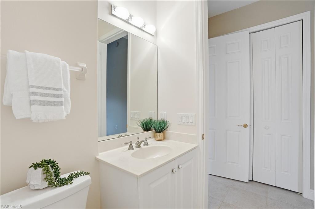 9263 Museo Circle, Unit 103 Naples, FL 34114 - Photo 25 of 49 Bathroom 2 featuring vanity, a closet, and light tile patterned floors