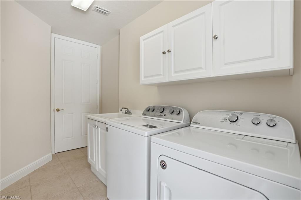 9263 Museo Circle, Unit 103 Naples, FL 34114 - Photo 28 of 49 Laundry room featuring cabinet space, light tile patterned floors, and separate washer and dryer