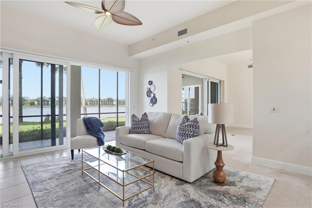 9263 Museo Circle, Unit 103 Naples, FL 34114 - Photo 3 of 49 Living room featuring a ceiling fan, a water view, and light tile patterned floors