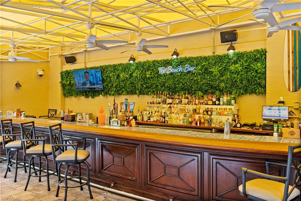 9263 Museo Circle, Unit 103 Naples, FL 34114 - Photo 49 of 49 Bar with a textured wall and a ceiling fan