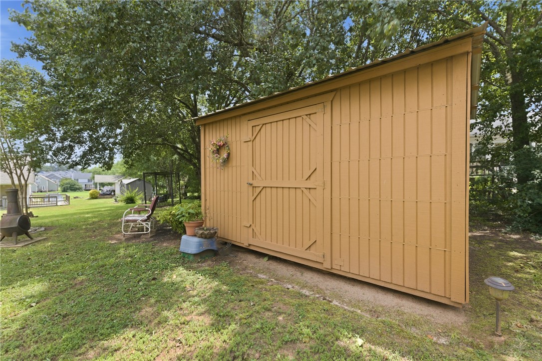 128 Kelly Lane Easley, SC 29642 - Photo 7 of 23 A quaint backyard shed provides practical outdoor storage in a verdant setting.