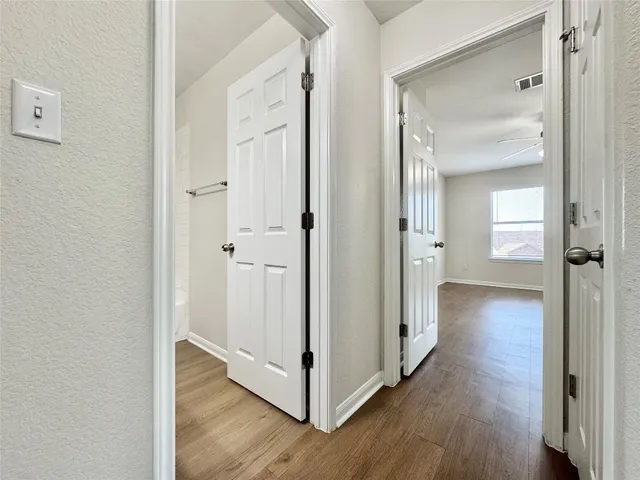 a view of a hallway with wooden floor