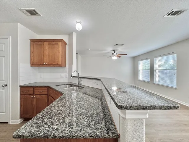 a kitchen with a granite countertop sink and a stove with granite countertops