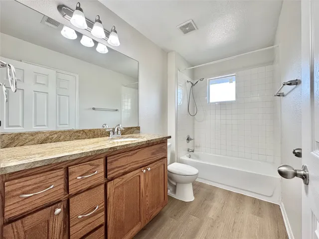 a bathroom with a granite countertop sink a toilet and bathtub