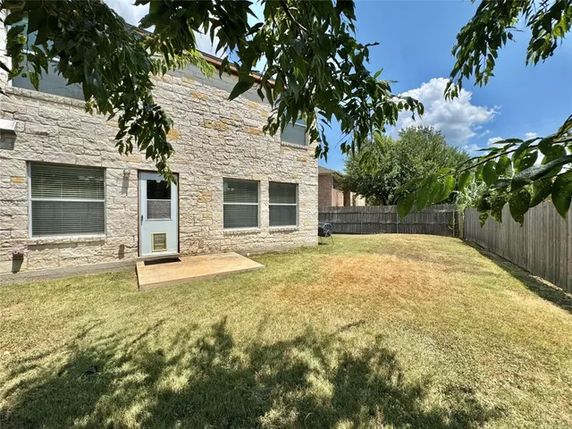 a view of a backyard with a garden and tree
