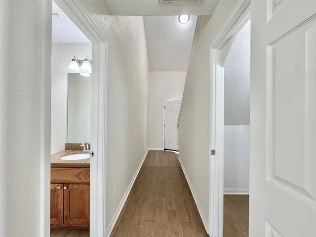 a view of a hallway with wooden floor and closet