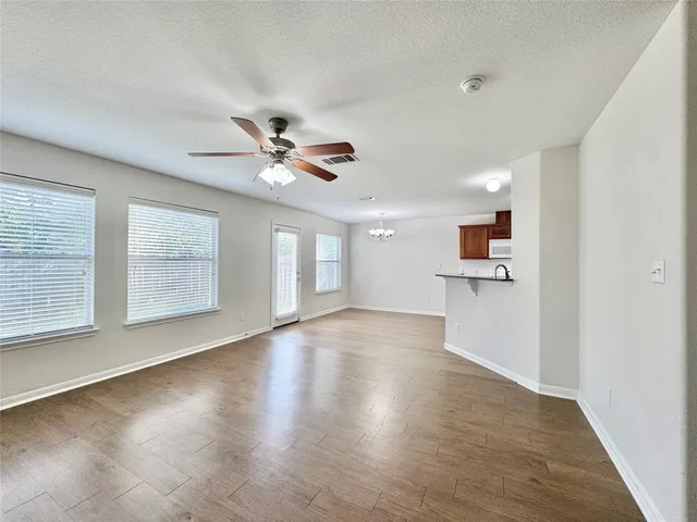 a view of empty room with wooden floor and window