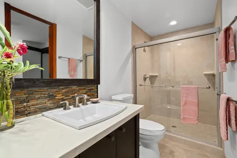 a bathroom with a sink toilet vanity and shower