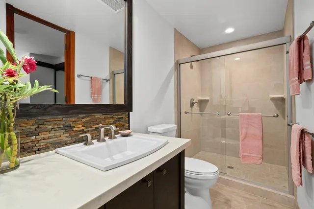 a bathroom with a sink toilet vanity and shower