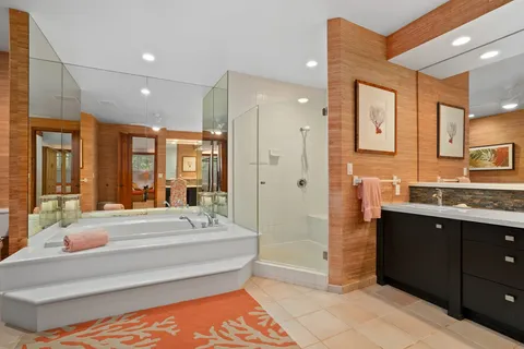 a bathroom with a tub a sink and mirrors