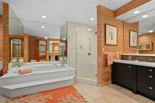 a bathroom with a tub a sink and mirrors