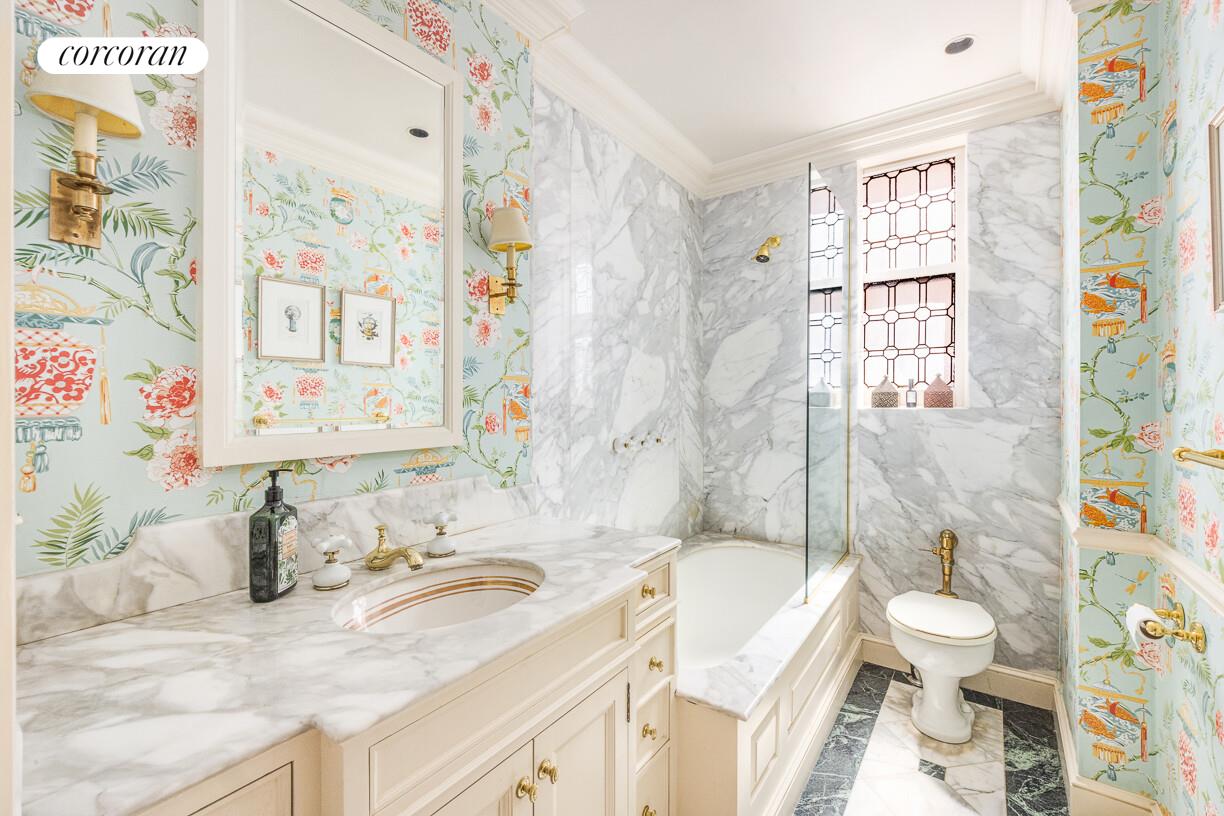 875 Park Avenue, Unit 8D9D Manhattan, NY 10075 - Photo 16 of 26 a bathroom with a granite countertop sink a toilet a mirror a bathtub and shower