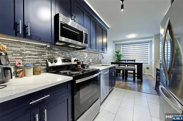 a kitchen with stainless steel appliances granite countertop a stove and a refrigerator