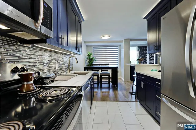 a kitchen with stainless steel appliances granite countertop a sink stove and cabinets