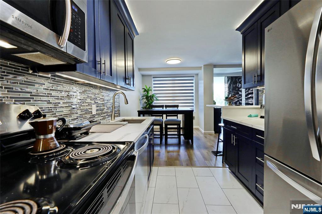 301 Beech Street, Unit 7A Hackensack, NJ 07601 - Photo 13 of 19 a kitchen with stainless steel appliances granite countertop a stove and a refrigerator