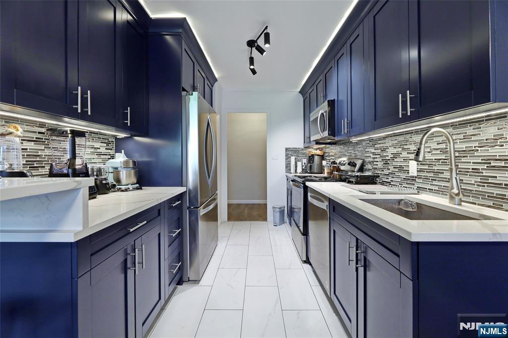 301 Beech Street, Unit 7A Hackensack, NJ 07601 - Photo 14 of 19 a kitchen with stainless steel appliances granite countertop a sink stove and cabinets