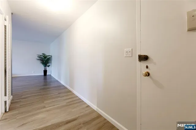 a view of a hallway with wooden floor and a chandelier