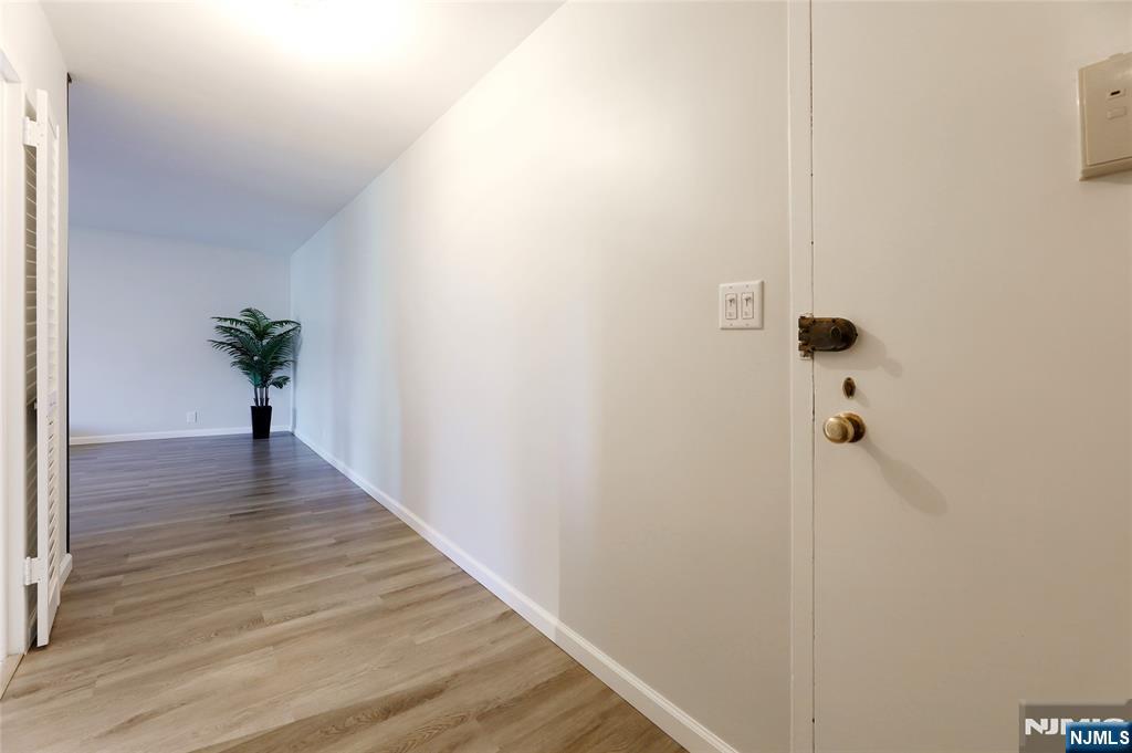 301 Beech Street, Unit 7A Hackensack, NJ 07601 - Photo 4 of 19 a view of a hallway with wooden floor and a chandelier