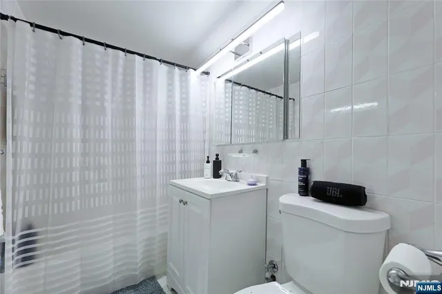a bathroom with a sink a toilet and shower curtain