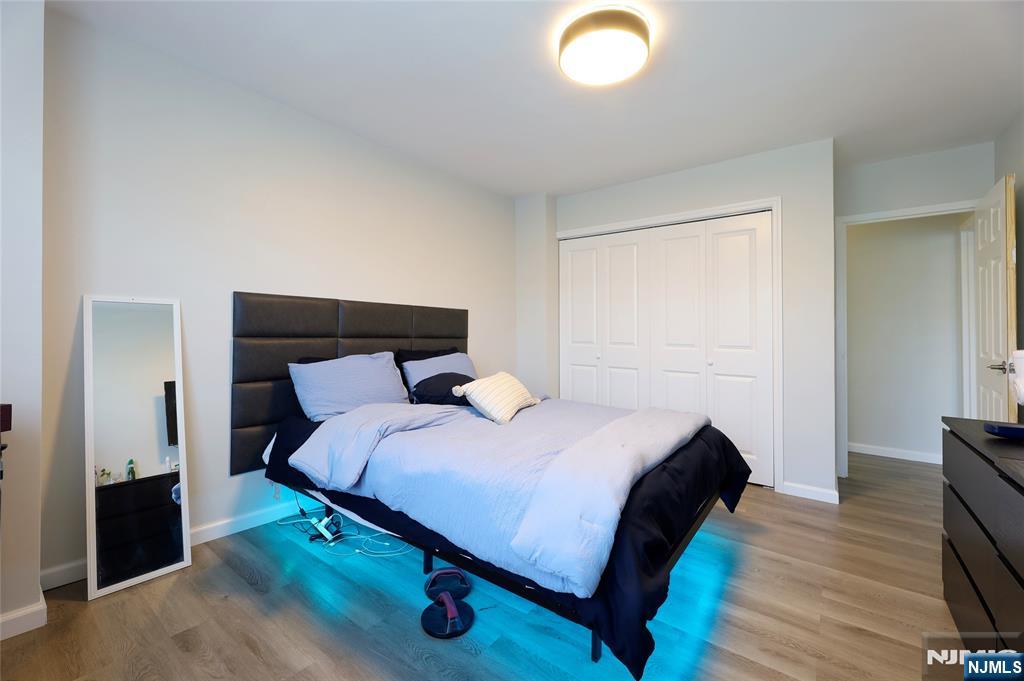 301 Beech Street, Unit 7A Hackensack, NJ 07601 - Photo 8 of 19 a bedroom with a bed and a lamp on dresser