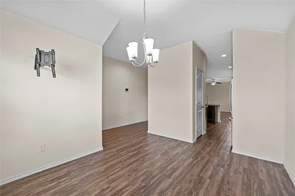 a view of a hallway with wooden floor and a chandelier