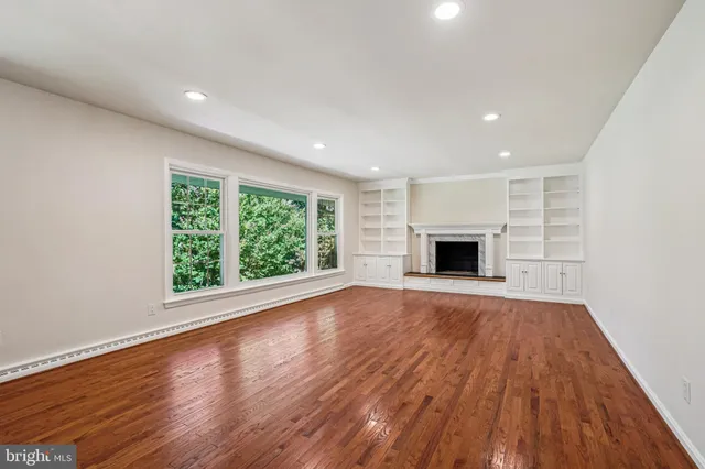 a view of empty room with wooden floor and fireplace
