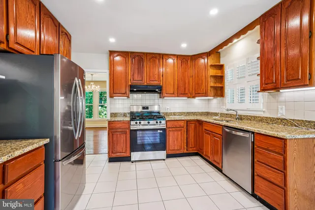 a metallic refrigerator freezer sitting in a kitchen