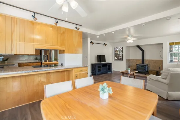 a living room with furniture a large window and wooden floor