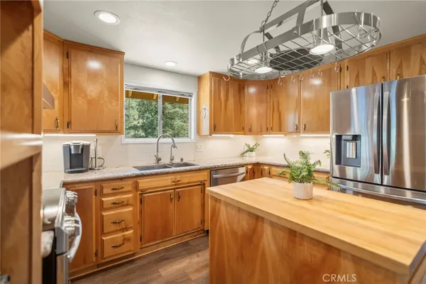 a kitchen with stainless steel appliances a sink window and cabinets
