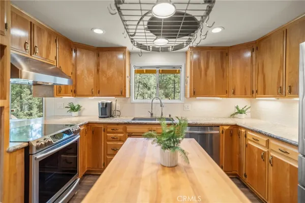 a kitchen with granite countertop a refrigerator and a sink