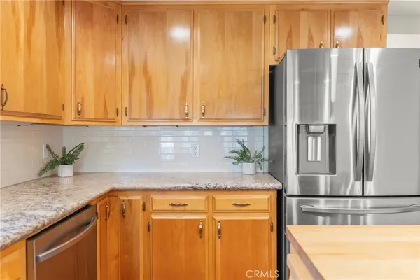 a kitchen with stainless steel appliances granite countertop a refrigerator and a sink