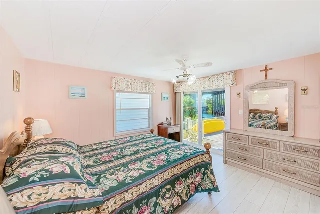 a bedroom with a bed a dresser next to a window