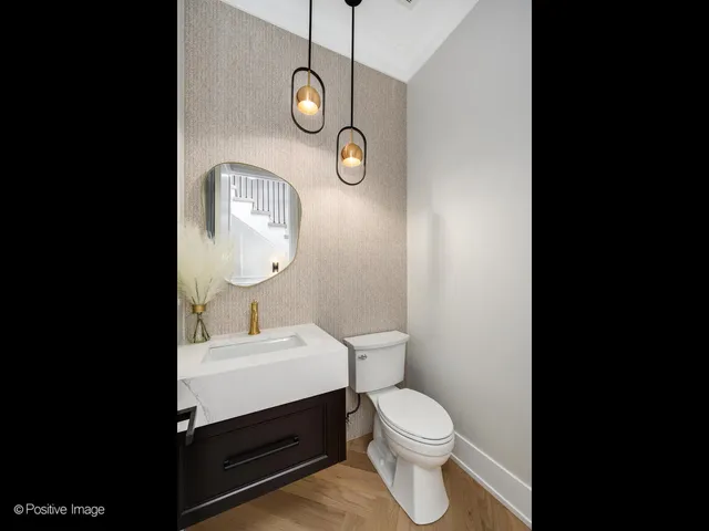 a bathroom with a toilet sink vanity and mirror