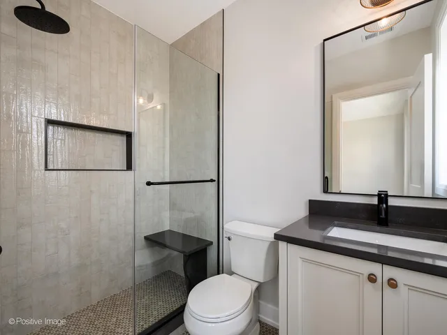 a bathroom with a granite countertop sink toilet a mirror and shower