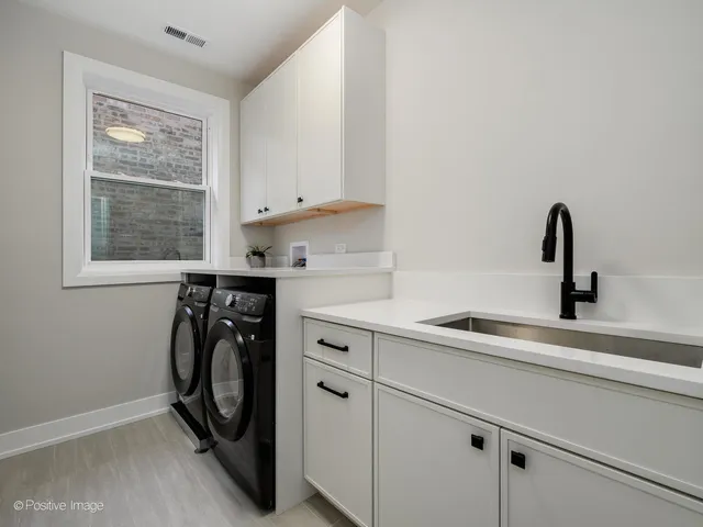 a utility room with cabinets washer and dryer