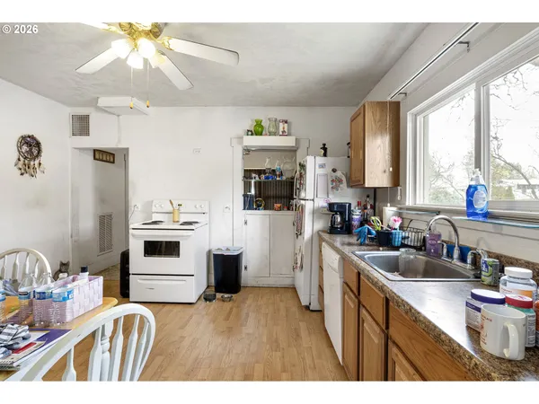 a kitchen with granite countertop a sink stove and refrigerator