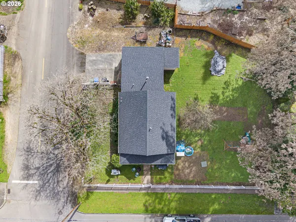 an aerial view of a house with a yard and large trees