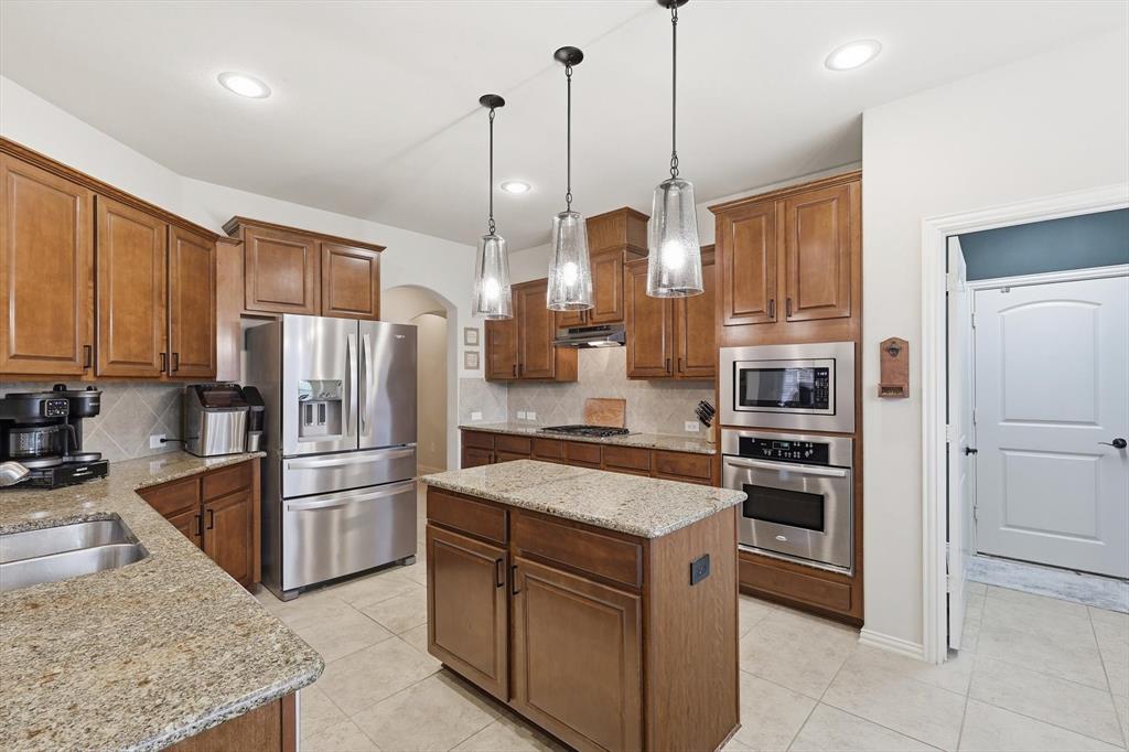 7105 Edwards Road Denton, TX 76208 - Photo 15 of 40 Spacious kitchen with updated light fixtures, stainless steel appliances, ample cabinetry, and center island.