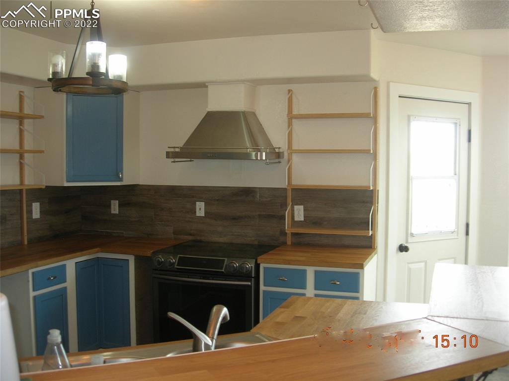 29750 Big Springs Road Calhan, CO 80808 - Photo 8 of 15 a kitchen with a cabinets and chandelier