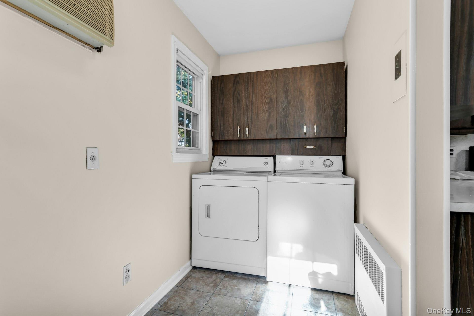 12 Violet Road Bayville, NY 11709 - Photo 20 of 42 Laundry area featuring cabinet space, radiator heating unit, washer and dryer, and tile patterned flooring