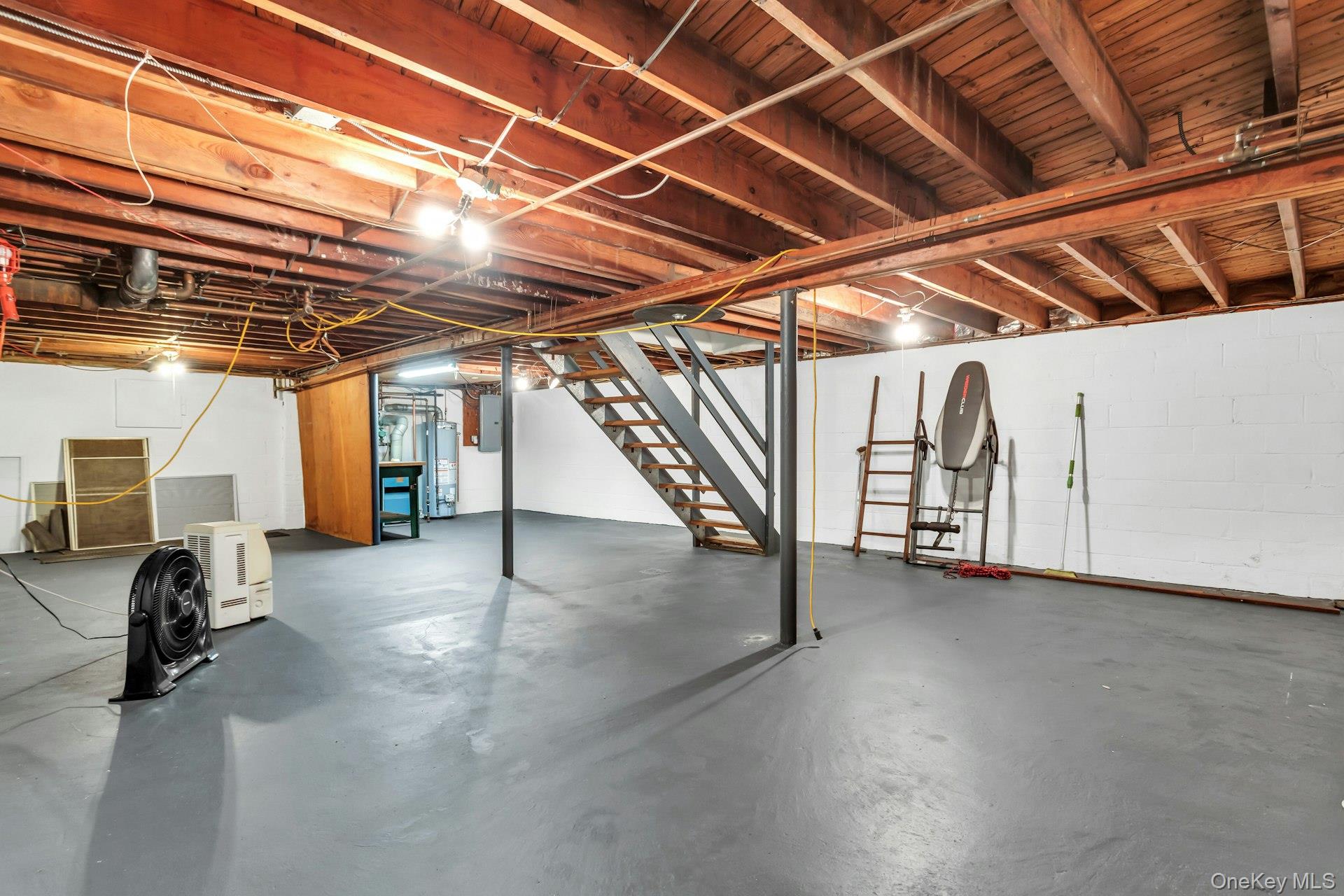 12 Violet Road Bayville, NY 11709 - Photo 36 of 42 Unfinished basement featuring stairs, water heater, and electric panel