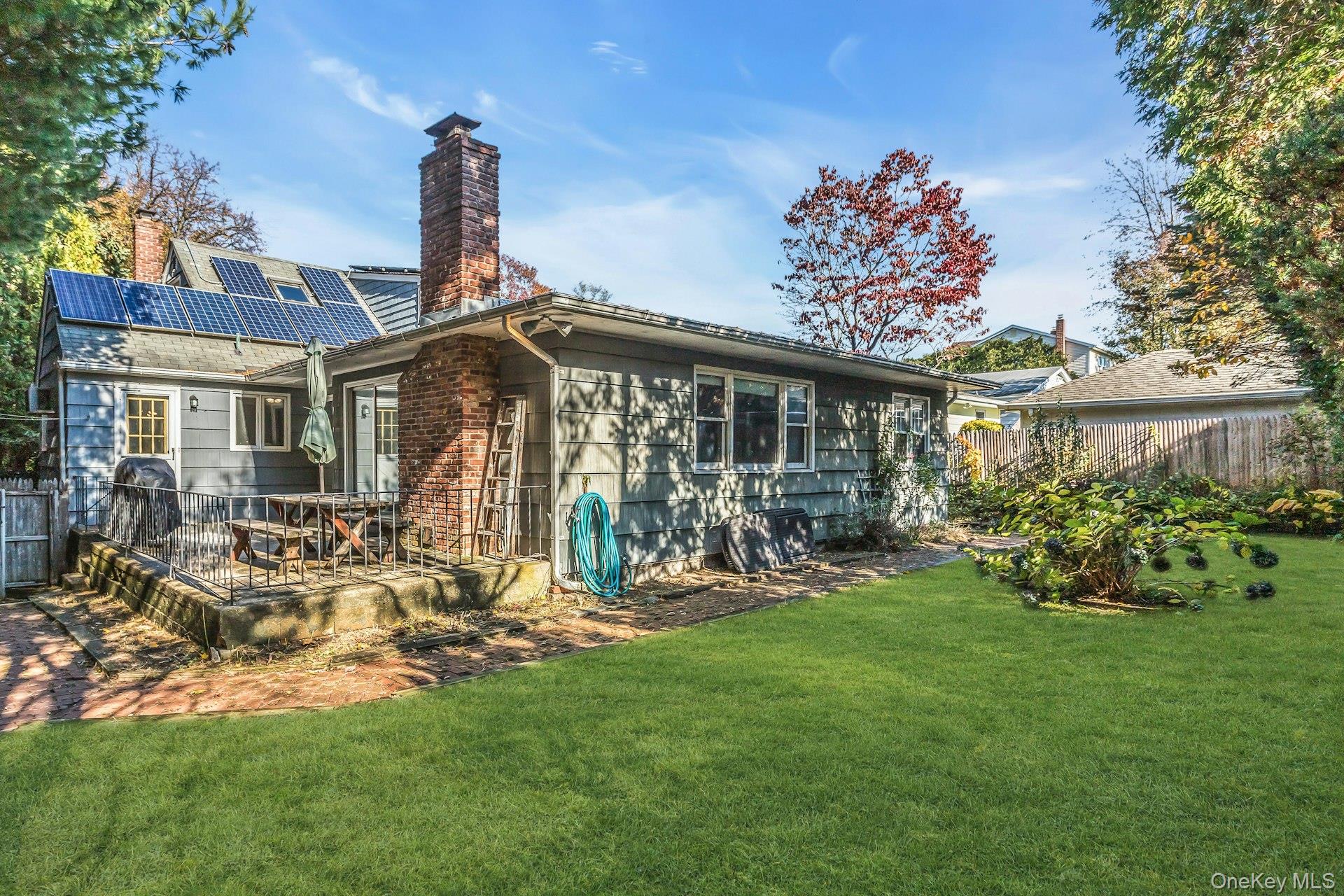 12 Violet Road Bayville, NY 11709 - Photo 37 of 42 Back of property featuring a chimney and roof mounted solar panels