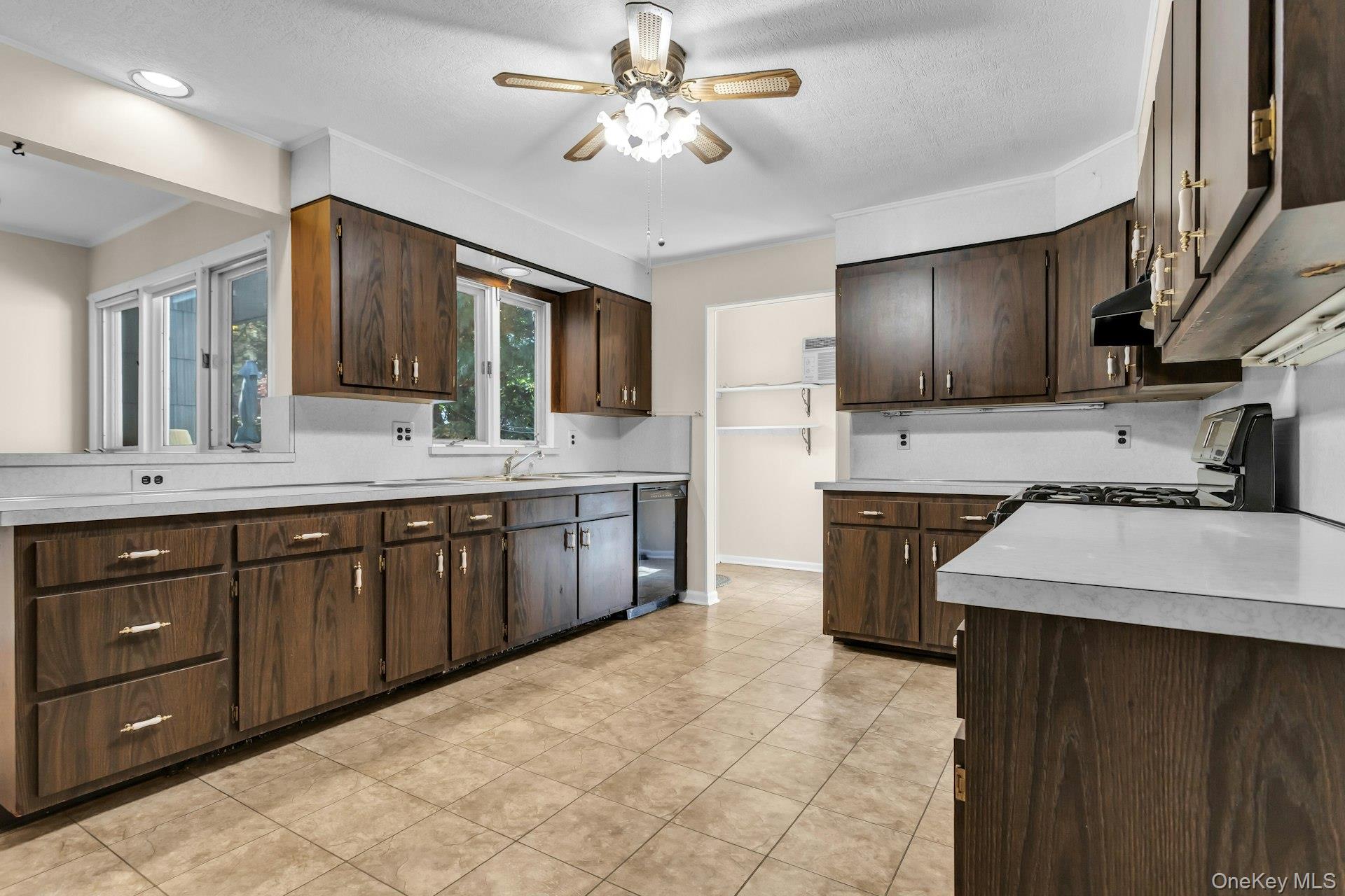12 Violet Road Bayville, NY 11709 - Photo 8 of 42 Large Eat in Kitchen with dark brown cabinetry, light countertops, and light tile patterned floors