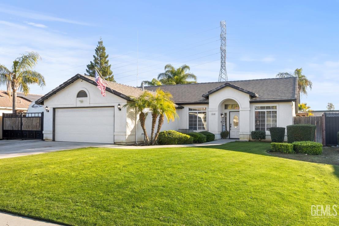 Undisclosed Address Bakersfield, CA 93308 - Photo 2 of 21 a view of a house with a yard and garage