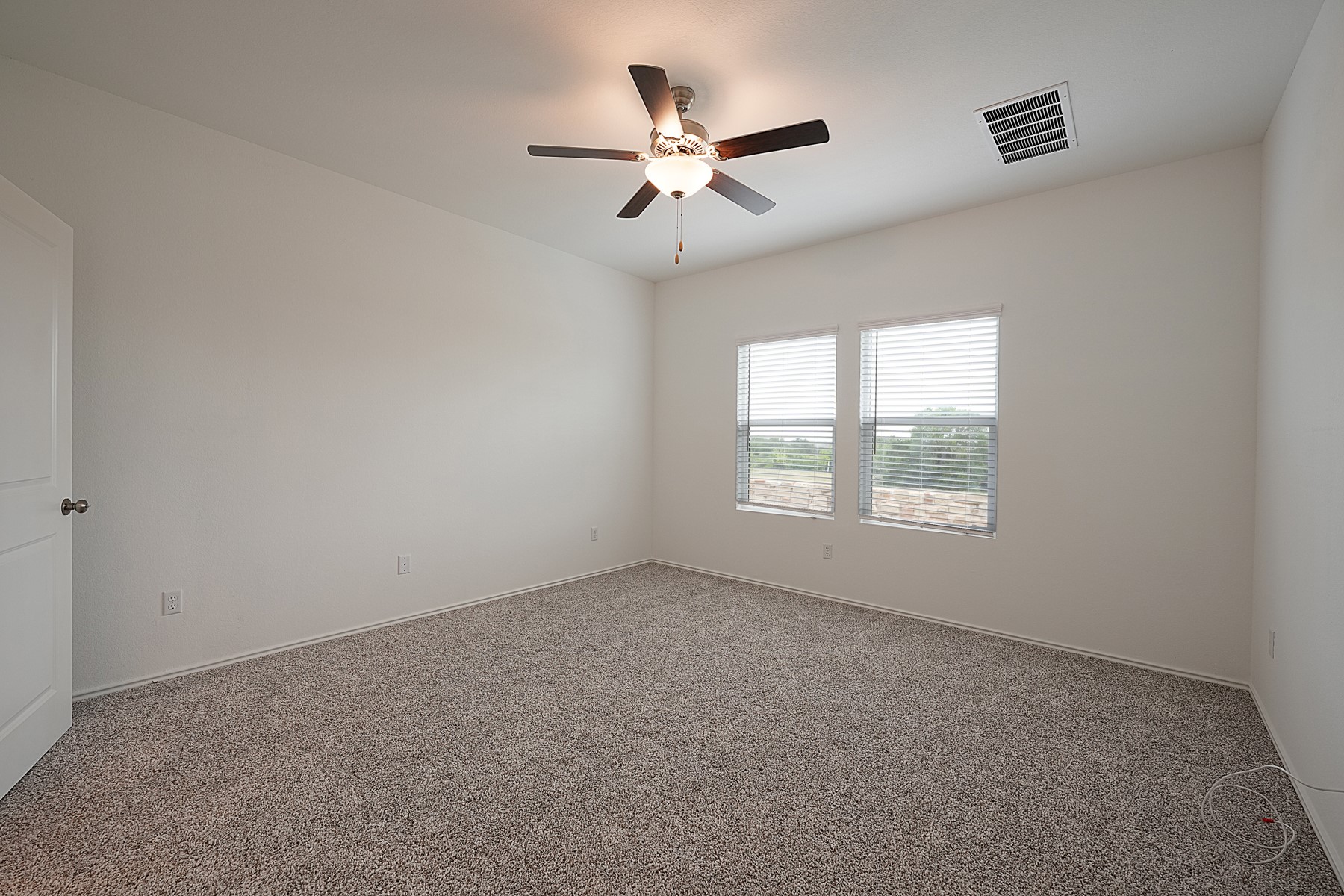 932 Mallow Road Leander, TX 78641 - Photo 14 of 34 A well-lit bedroom features plush carpeting and a modern ceiling fan, with serene outdoor views.