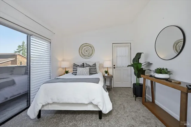 a living room with a table a potted plant and a dresser