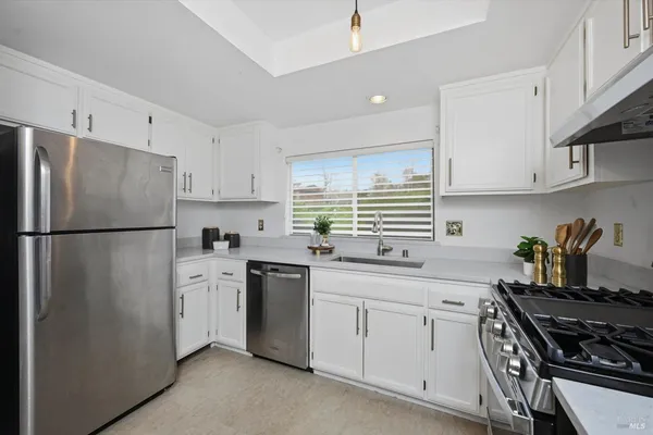 a kitchen with stainless steel appliances a refrigerator sink and cabinets