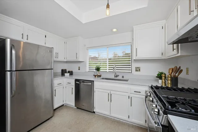 a kitchen with stainless steel appliances a refrigerator sink and cabinets